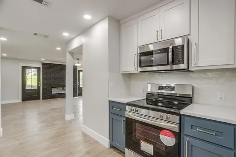 a kitchen with stainless steel appliances granite countertop a stove and a microwave