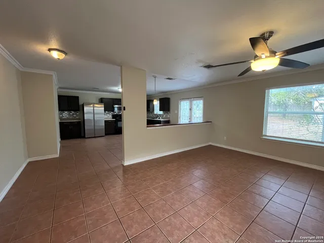 a view of a kitchen and an empty room with a window