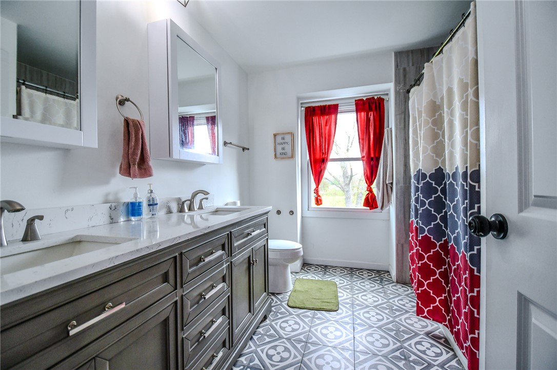 6169 Dayton Farmersville Road Dayton, OH 45417 - Photo 35 of 64 This bathroom features a double vanity and patterned tile flooring, creating a bright and inviting space.