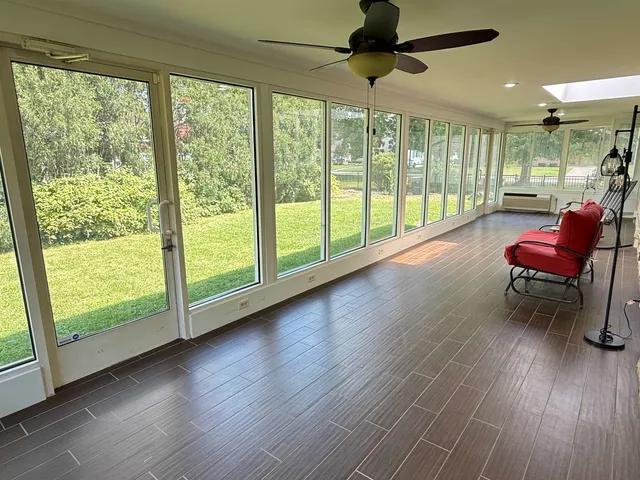 a view of a livingroom with furniture a ceiling fan and wooden floor