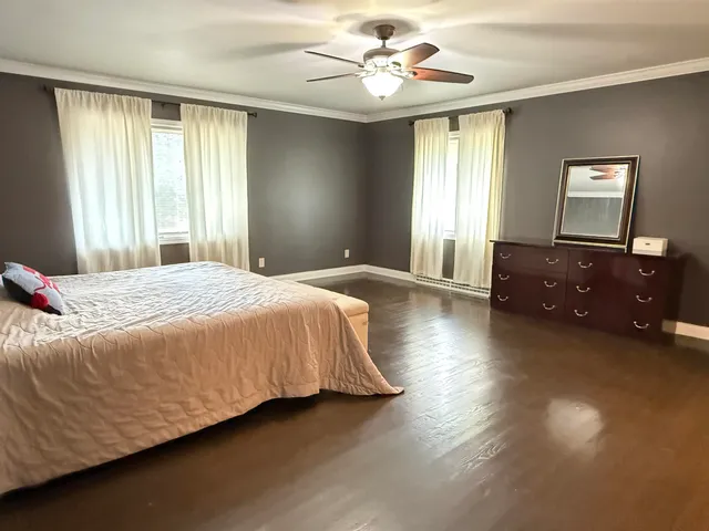 a spacious bedroom with a bed and a chandelier