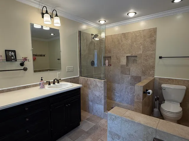 a bathroom with a double vanity sink toilet and shower