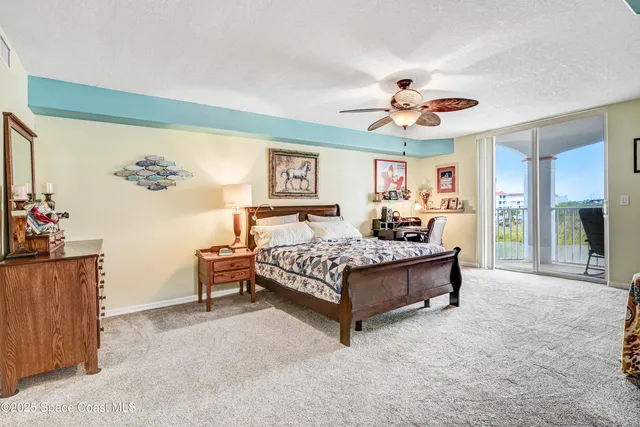 a bedroom with a bed and a flat tv screen on dresser