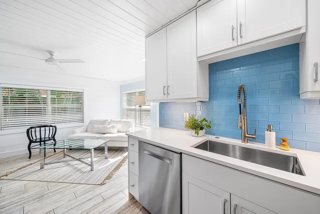 a kitchen with stainless steel appliances a sink a stove and white cabinets