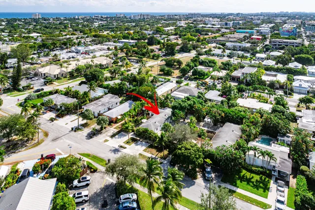 an aerial view of residential houses with outdoor space and trees