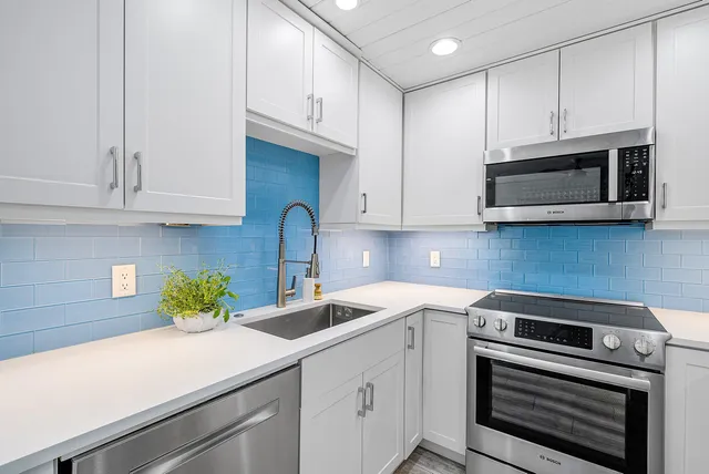 a kitchen with appliances a sink and cabinets