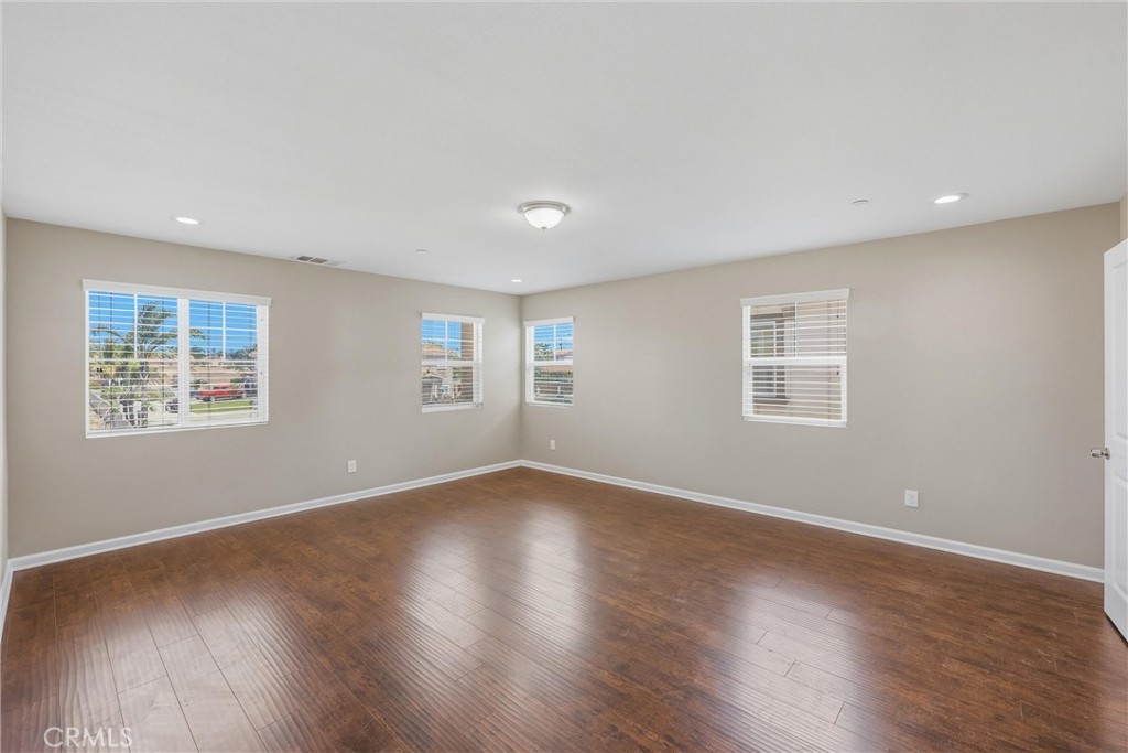 956 West Tibbot Street Rialto, CA 92377 - Photo 24 of 37 a view of an empty room with wooden floor and a window