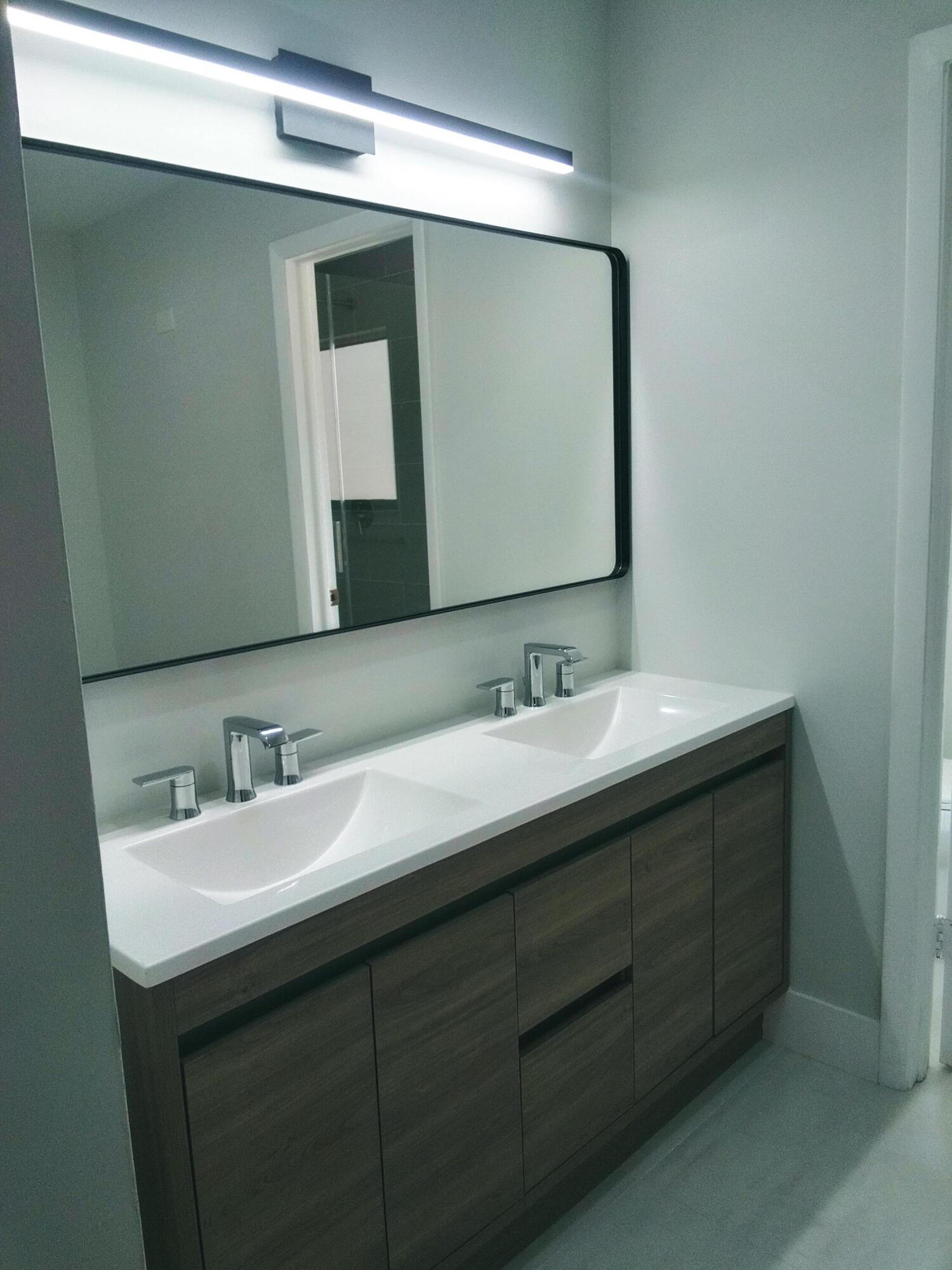 9727 North New River Canal Road, Unit 629 Plantation, FL 33324 - Photo 16 of 28 a bathroom with a double vanity sink and mirror