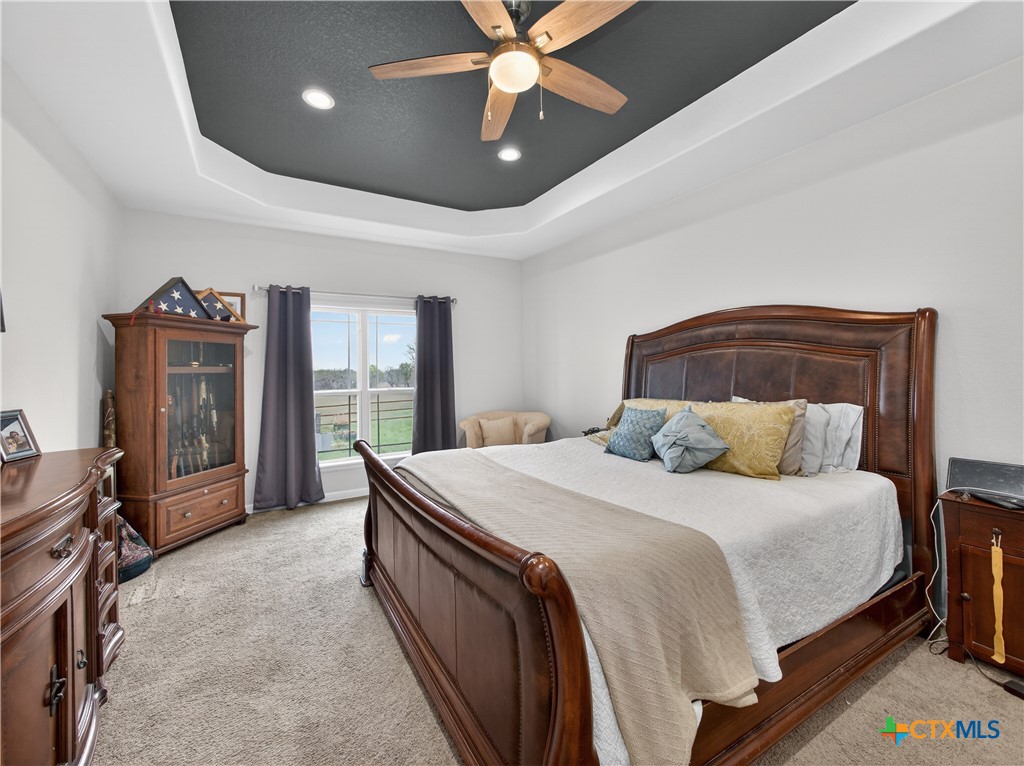 494 Flash Circle Luling, TX 78648 - Photo 14 of 44 a bedroom with a large bed and a chandelier