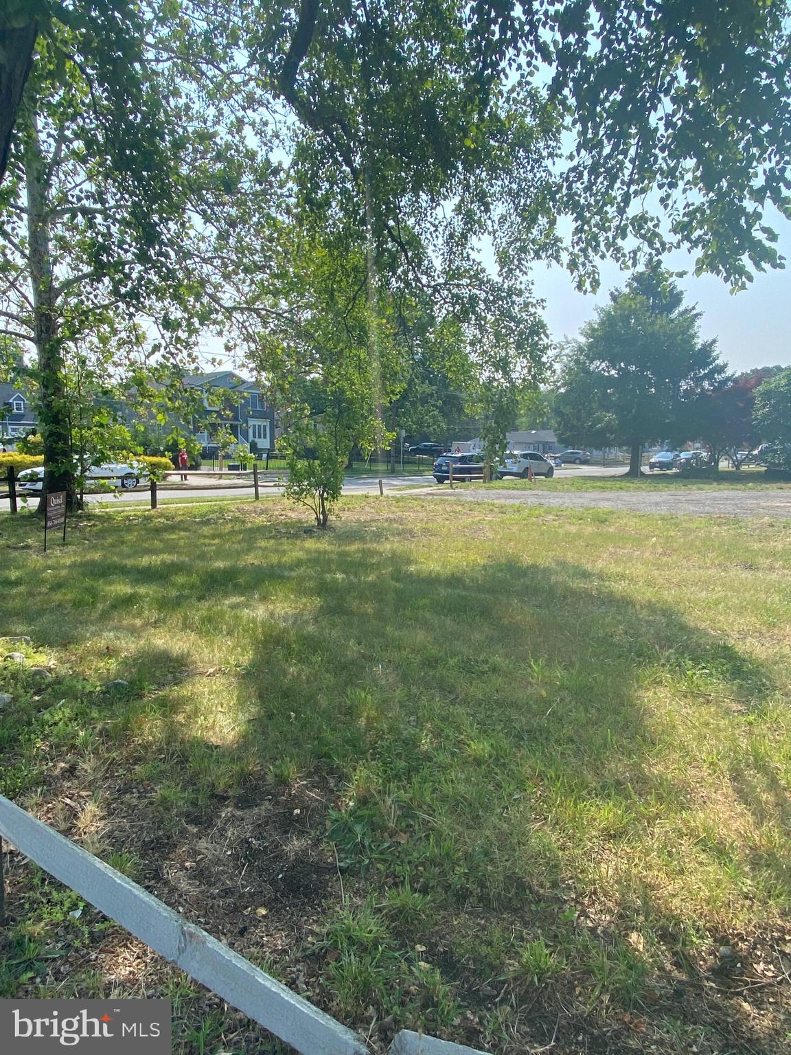 a big yard with lots of green space and trees in the background