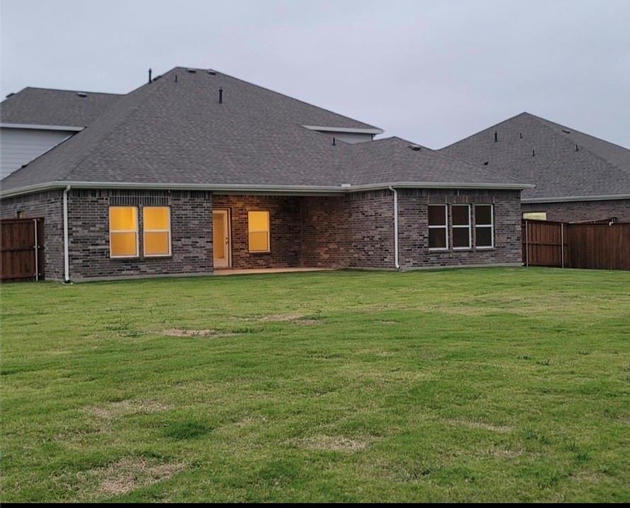 785 Vineyard Way Forney, TX 75126 - Photo 11 of 12 The property features a spacious backyard with a lawn, a brick exterior, and a covered patio area