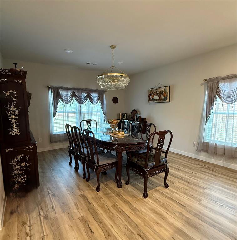 785 Vineyard Way Forney, TX 75126 - Photo 6 of 12 Dining area featuring wood-finish flooring, recessed lighting, and a tiered glass chandelier