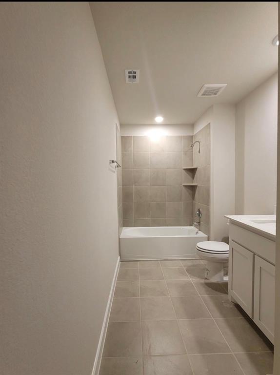 785 Vineyard Way Forney, TX 75126 - Photo 7 of 12 Bathroom featuring a white tub, tiled shower surround with built-in shelves, white toilet, and a vanity with a white countertop