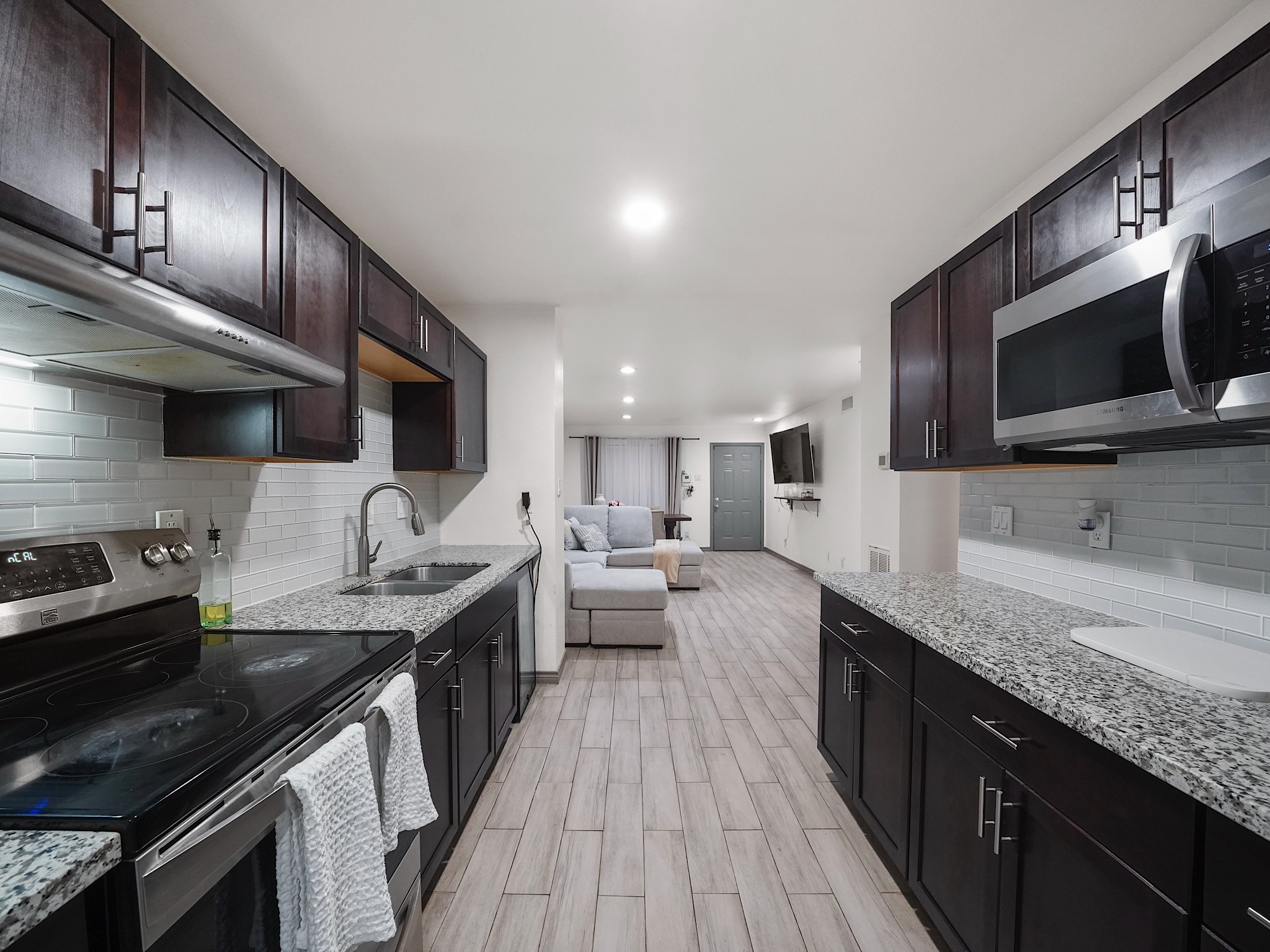 a kitchen with stainless steel appliances kitchen island granite countertop a sink stove and oven