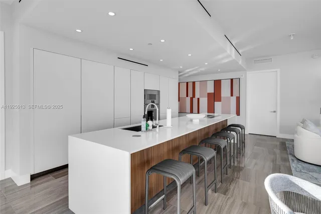 a large white kitchen with a large window