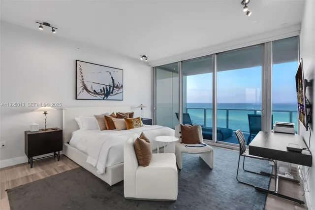 a bedroom with a bed a large window and couch