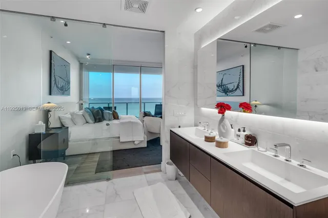 a bathroom with a tub a sink double vanity and shower