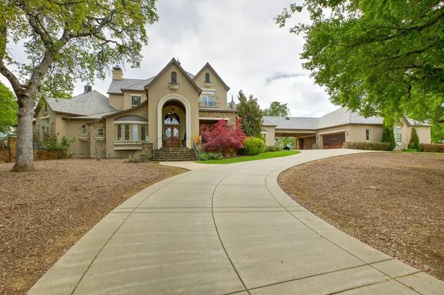 a front view of a house with a yard and tree s