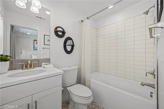 a bathroom with a toilet sink vanity tub and shower
