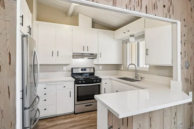 a kitchen with white cabinets and appliances