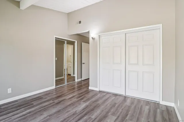 an empty room with wooden floor and closet