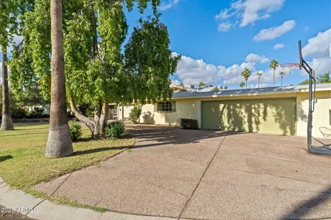 a view of a house with a yard and potted plants