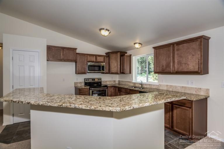 17306 Kingsburg Road Bend, OR 97707 - Photo 5 of 22 a kitchen with granite countertop stainless steel appliances granite countertop a sink stove and microwave