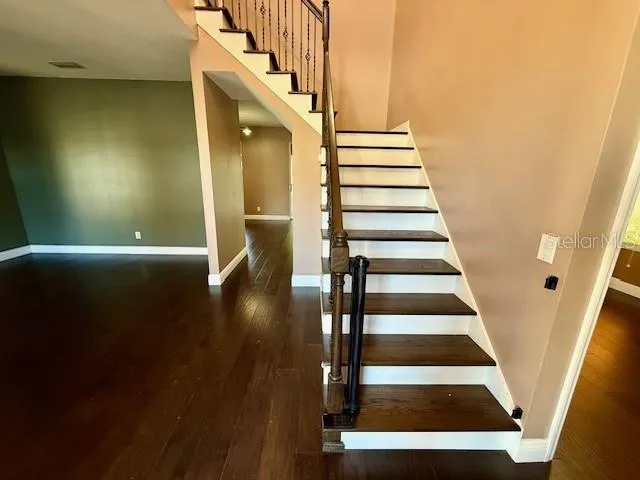 a view of entryway and hall with wooden floor