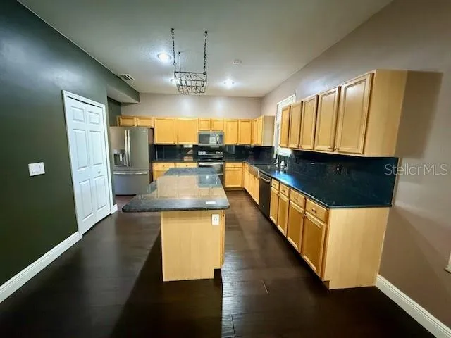 a kitchen with counter top space and wooden floor