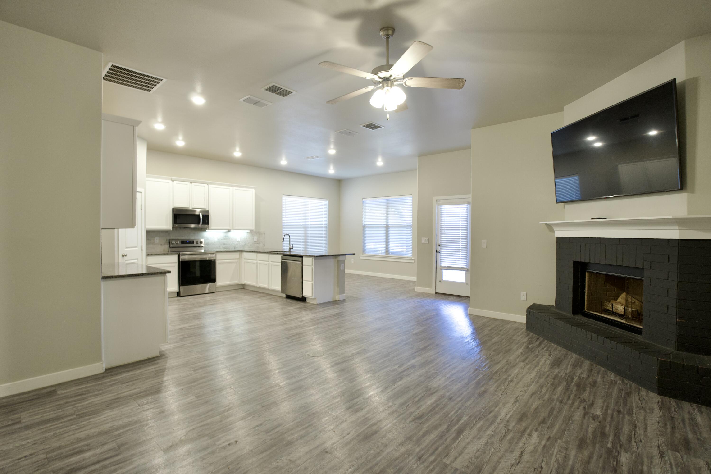 1604 137th Street Lubbock, TX 79423 - Photo 4 of 19 a view of kitchen with a fireplace wooden floor and windows