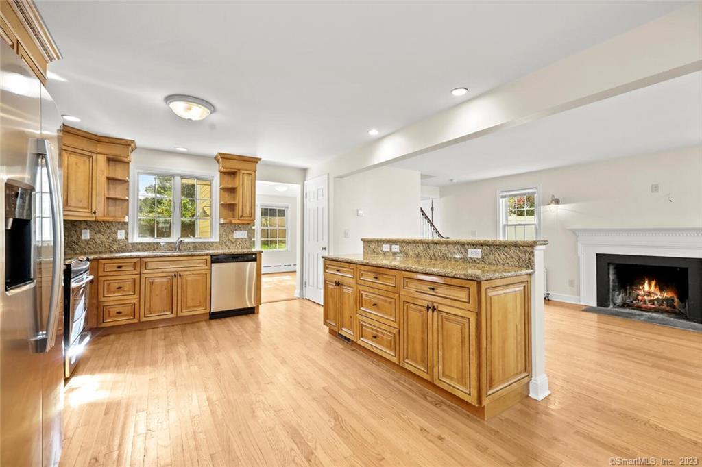 a kitchen with stainless steel appliances granite countertop a stove and a wooden floors