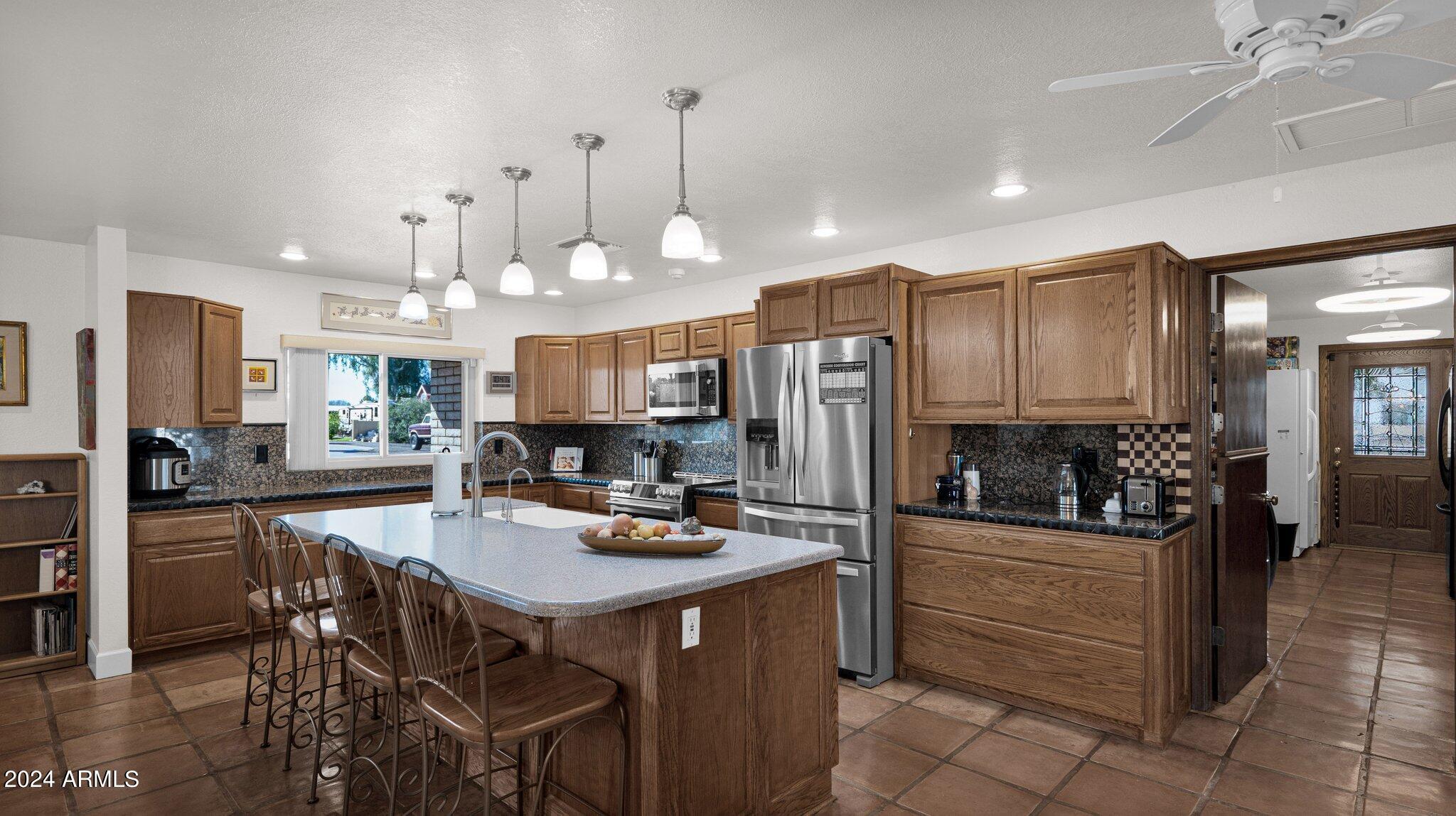 814 East Harwell Road Gilbert, AZ 85234 - Photo 15 of 35 a kitchen with stainless steel appliances a refrigerator a stove a sink a dining table and chairs with wooden floor