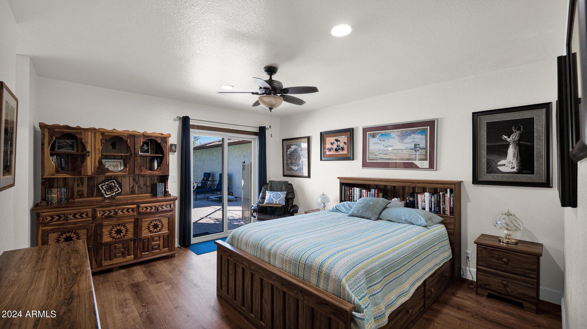 814 East Harwell Road Gilbert, AZ 85234 - Photo 21 of 35 a bedroom with a bed a dresser and wooden floor