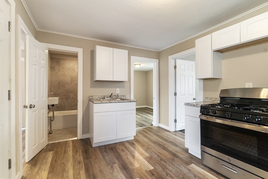 43 Wait Street Springfield, MA 01104 - Photo 1 of 18 a kitchen with a refrigerator stove and white cabinets