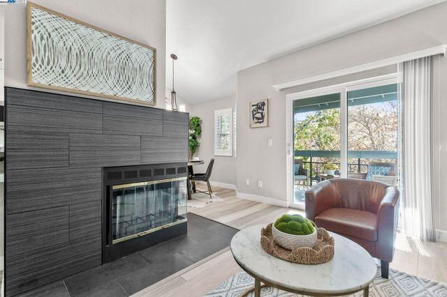a living room with furniture a fireplace and a large window