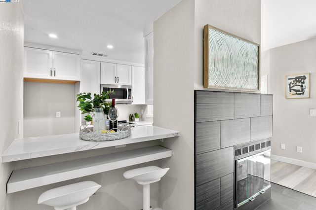 a kitchen with kitchen island white cabinets and white appliances
