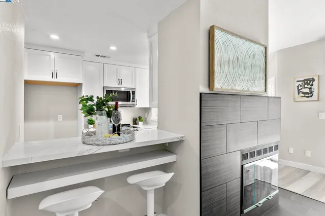 a kitchen with kitchen island white cabinets and white appliances