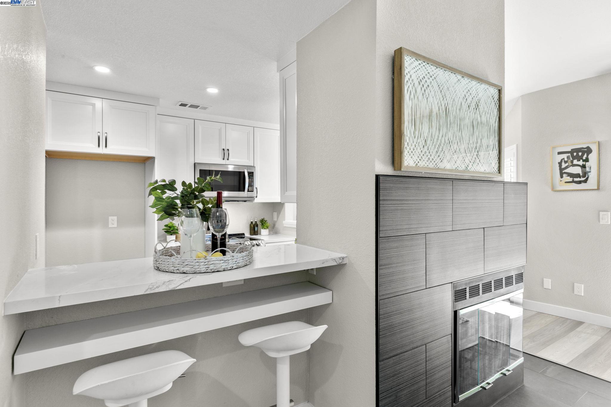 8170 Mountain View Drive, Unit F Pleasanton, CA 94588 - Photo 15 of 51 a kitchen with kitchen island white cabinets and white appliances