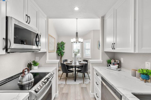 a kitchen with stainless steel appliances kitchen island granite countertop a sink a stove and a microwave