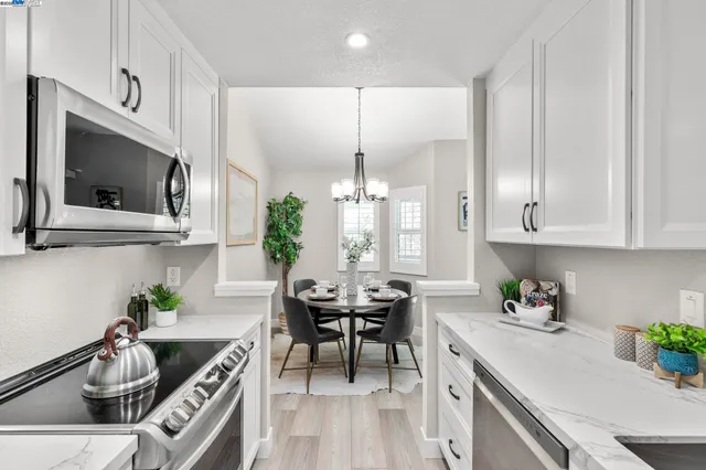 a kitchen with stainless steel appliances kitchen island granite countertop a sink a stove and a microwave