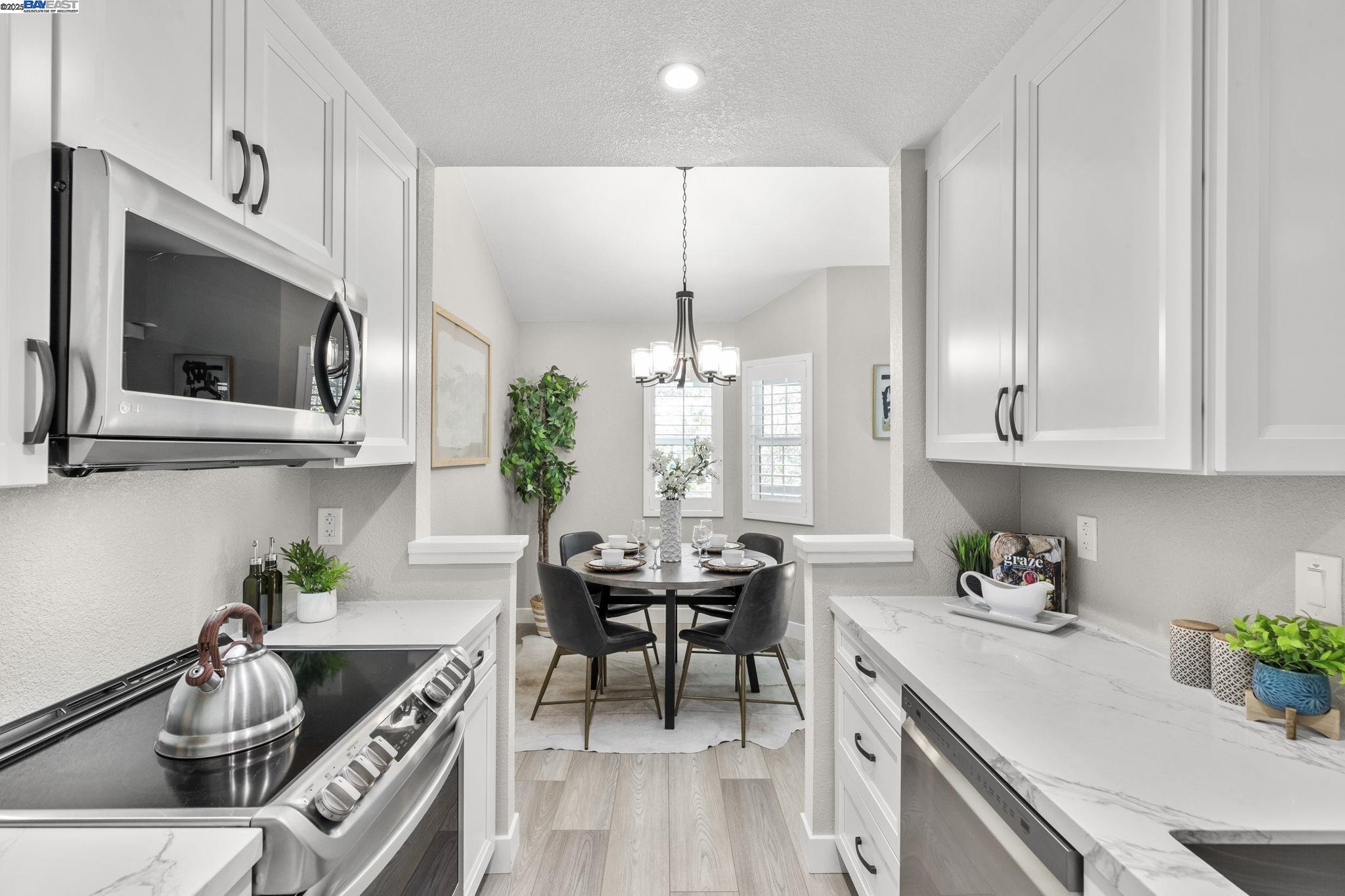 8170 Mountain View Drive, Unit F Pleasanton, CA 94588 - Photo 16 of 51 a kitchen with stainless steel appliances kitchen island granite countertop a sink a stove and a microwave