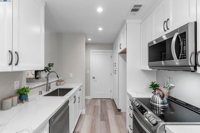 a kitchen that has a sink and a stove top oven