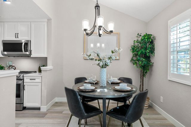 a dining room with furniture potted plants and wooden floor