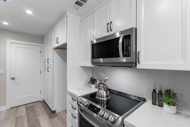 a kitchen with stainless steel appliances a sink a stove a microwave and cabinets