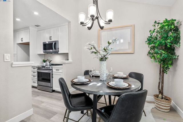 a dining room with furniture a kitchen and a chandelier