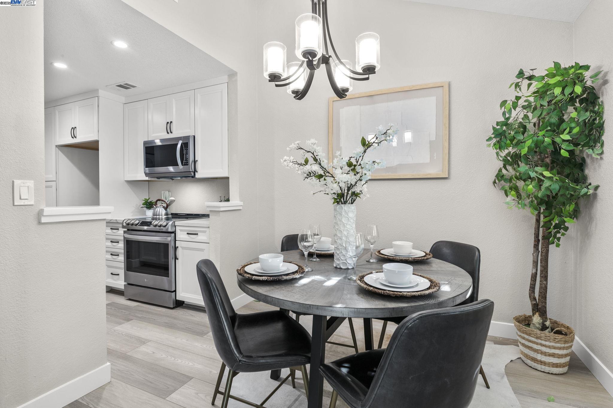 8170 Mountain View Drive, Unit F Pleasanton, CA 94588 - Photo 23 of 51 a dining room with furniture a kitchen and a chandelier