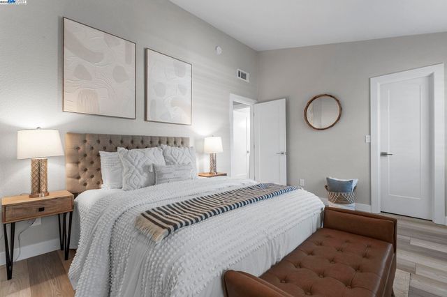 a bedroom with a bed and a lamp on dresser