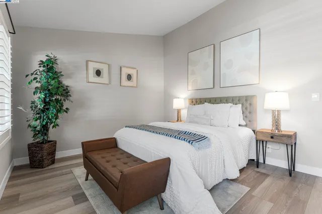 a bedroom with a bed and a potted plant