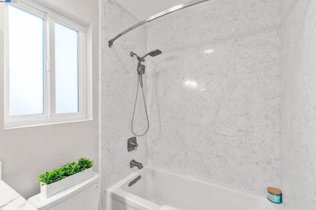 a bathroom with a bath tub with a shower