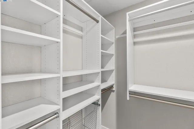 a view of walk in closet with empty racks